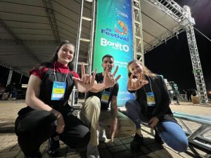 Três jovens fazendo sinal de rock and roll durante a última edição do festival de inverno em Bonito